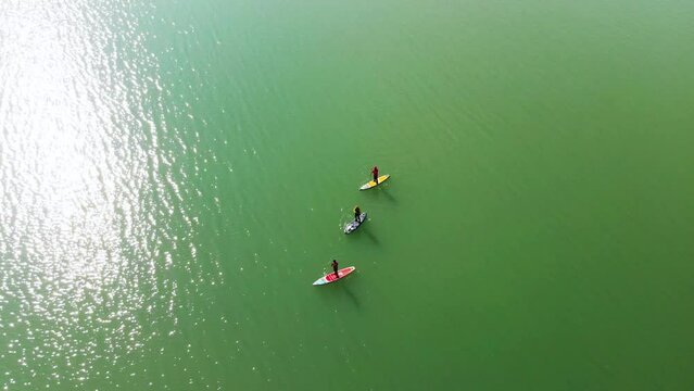 Poeple is paddling on sup board in the winter lake