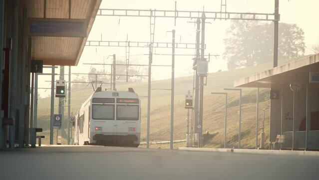 Cinematic low to ground, outdoor train leaving station during golden hour in Europe