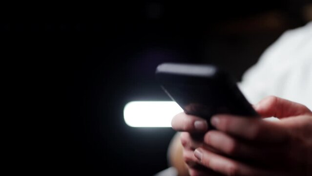 Young male hands close up holding his new modern smartphone and chatting fast with his friends remotely on social media accounts using downloaded app