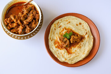 Kerala paratha porotta meat beef curry roti Malabar parotta barotta is Indian layered flatbread for breakfast snack, popular street food India ramadan festival . Maida wheat flour Cooking the dough.