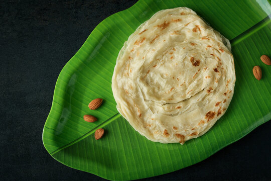 Kerala paratha porotta meat beef curry roti Malabar parotta barotta is Indian layered flatbread for breakfast snack, popular street food India ramadan festival . Maida wheat flour Cooking the dough.