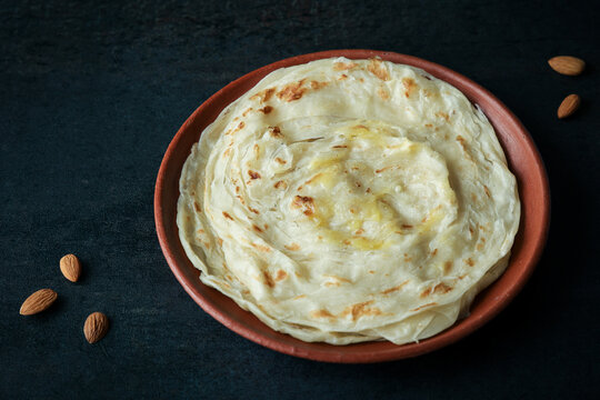 Kerala paratha porotta meat beef curry roti Malabar parotta barotta is Indian layered flatbread for breakfast snack, popular street food India ramadan festival . Maida wheat flour Cooking the dough.