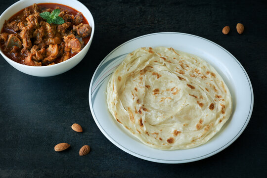 Kerala paratha porotta meat beef curry roti Malabar parotta barotta is Indian layered flatbread for breakfast snack, popular street food India ramadan festival . Maida wheat flour Cooking the dough.