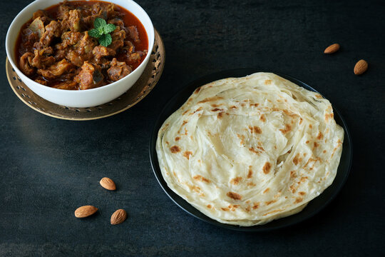 Kerala paratha porotta meat beef curry roti Malabar parotta barotta is Indian layered flatbread for breakfast snack, popular street food India ramadan festival . Maida wheat flour Cooking the dough.