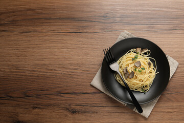 Tasty spaghetti with truffle on wooden table, top view. Space for text