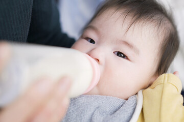 寝ながらミルクを飲むアジア人の赤ちゃん	