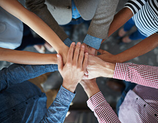 We say yes to team success. Top view of co-workers hand put together in an expression of unity and team spirit.