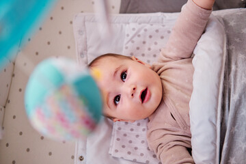 Baby playing with musical crib mobile