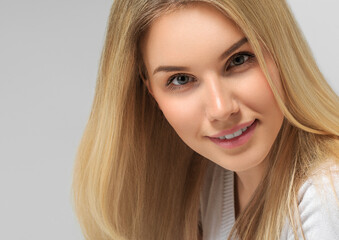 Naklejka premium Long smooth blonde hairstyle beauty woman close up portrait. Color background gray