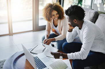 Weve managed our budget so well this month. Shot of a young couple going through their paperwork together at home.