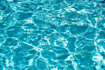 Background of blue water in swimming pool with sun reflection, ripple water wave in pool. Clear water background.