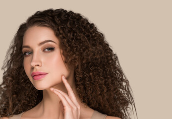 Curly long brunette hair woman touching face beauty close up female portrait. Color backgound brown