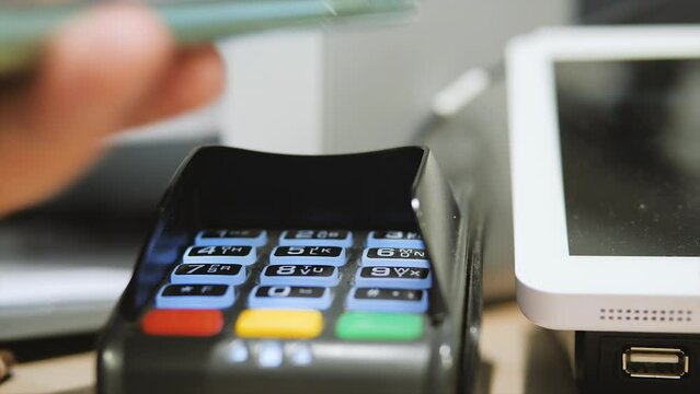 Contactless payments by modern phone via pin pad close-up. Payment terminal.