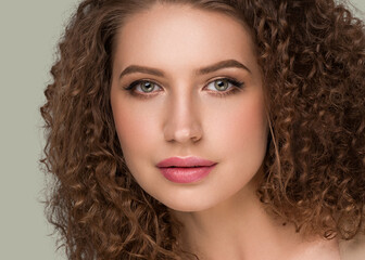 Curly long brunette hair woman beauty portrait, female glamour face. Color backgound green
