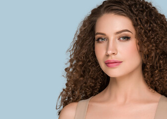 Curly long brunette hair woman beauty portrait, female glamour face. Color backgound blue