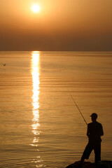 silhouette of a fisherman at sunset