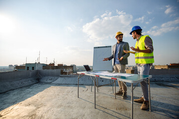 Fototapeta na wymiar Team of architects people in group on construciton site check documents and business workflow.