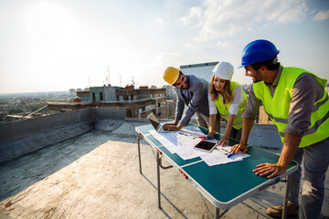 Team of architects people in group on construciton site check documents and business workflow.