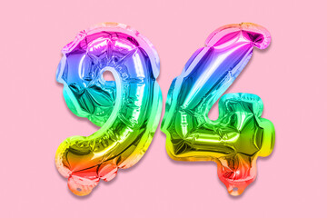 Rainbow foil balloon number, digit ninety four on a pink background. Birthday greeting card with inscription 94. Top view. Numerical digit. Celebration event, template.