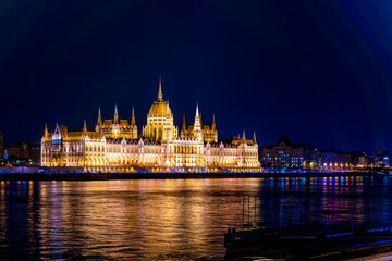 Fototapeta premium Beautiful architecture illuminated by lanterns. A magical view of the ancient city. Hungarian parliament building at night, budapest, hungary. A beautiful old building on the danube river