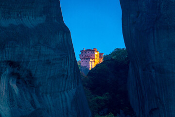 Fototapeta na wymiar Rocks of meteora, greece. Beautiful view of the monastery through a crevice between huge stones.