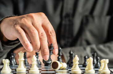 The hands of a business male business associate confident in strategy after playing chess to analyze and develop new planning. Concept of leadership and teamwork for victory and success in business.
