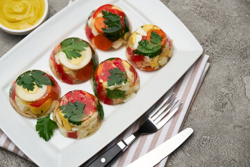 Portion of delicious chicken aspic on a plate isolated on concrete table