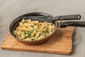 Pasta, mushrooms, onion cheese in a pan