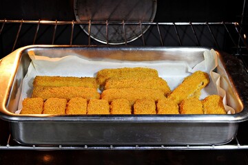 Baking frozen fish fingers in an oven. Shallow depth of field