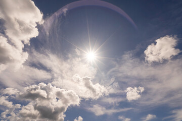 Shining sun on clear blue sky white clouds with lens flare of sunlight on sky background Bright sun on blue sky Concept Nature and environment background