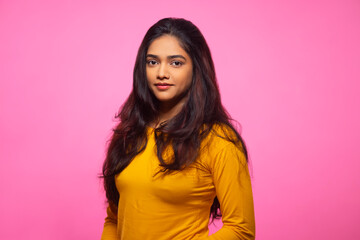 Young woman in yellow dress posing in front of camera