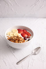 bowl of granola cereal with yogurt and berries isolated on white background