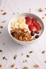 bowl of granola cereal with yogurt and berries isolated on white background
