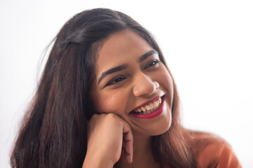 Close-up portrait of smiling woman with hand on cheek