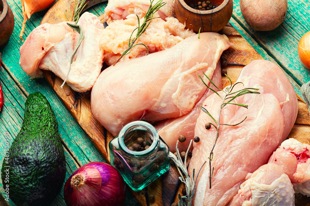 Wall mural Uncooked chicken meat on cutting board