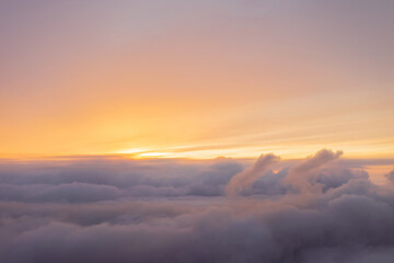 intense fabulous sunrise over clouds in warm colors, view from the plane