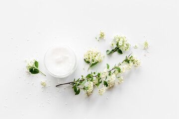 White moisturizing cream cosmetic for spa treatment with blossoms flowers