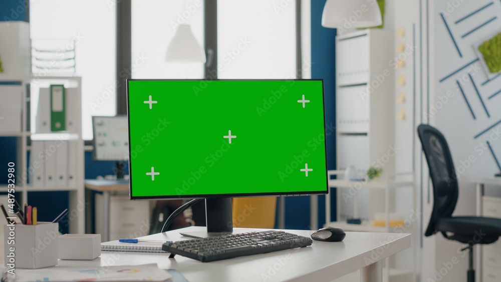 Poster close up of green screen on computer monitor at empty desk. device with isolated mock up template an