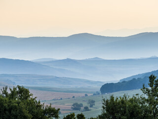 Dream landscape in the morning lights with misty mountains in the background. Nature landscape background view.