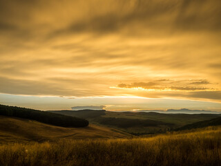 Obraz premium Stormy weather, with dramatic sky at sunset. Dramatic dark-yellow storm clouds over a autumn field .