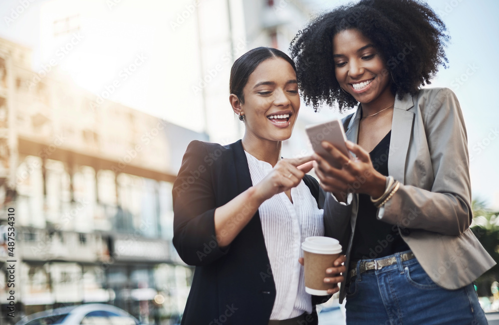 Poster reaching out to new networks. shot of two businesswomen looking at something on a cellphone in the c