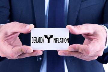 businessman holding banner with inflation and deflation concept