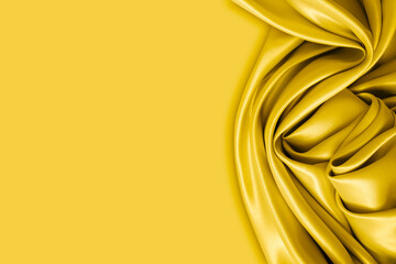 Beautiful elegant wavy yellow satin silk luxury cloth fabric with monochrome background design. Copy space