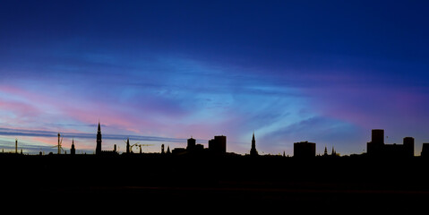Copenhagen city skyline with the city as a silhouette on a colorful night sky.