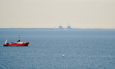 A ship on the Øresund strait with Barsebäck Nuclear Power Plant in the background.