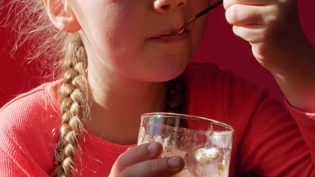 Child eating yogurt jelly pink background. Dairy product diet Lactobacillus Acidophilus, healthy homemade breakfast menu. Kids healthcare. Vegan food nut milk gelatin non-dairy dessert Protein pudding