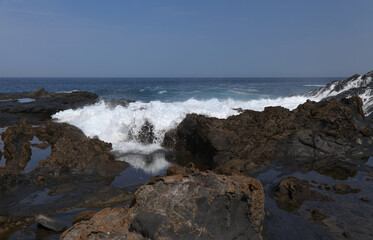 Fototapeta na wymiar Gran Canaria, north coast, rockpools around Puertillo de Banaderos area protected from the ocean waves by volcanic rock barrier