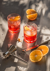 Red cocktail Campari with orange and ice copy space grey background.