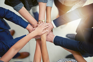 Making business better together. Closeup shot of a group of businesspeople joining their hands together in unity.