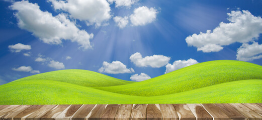 Panorama of wooden table with green grass field on a hill with beautiful blue sky with clouds background. natural background concept.